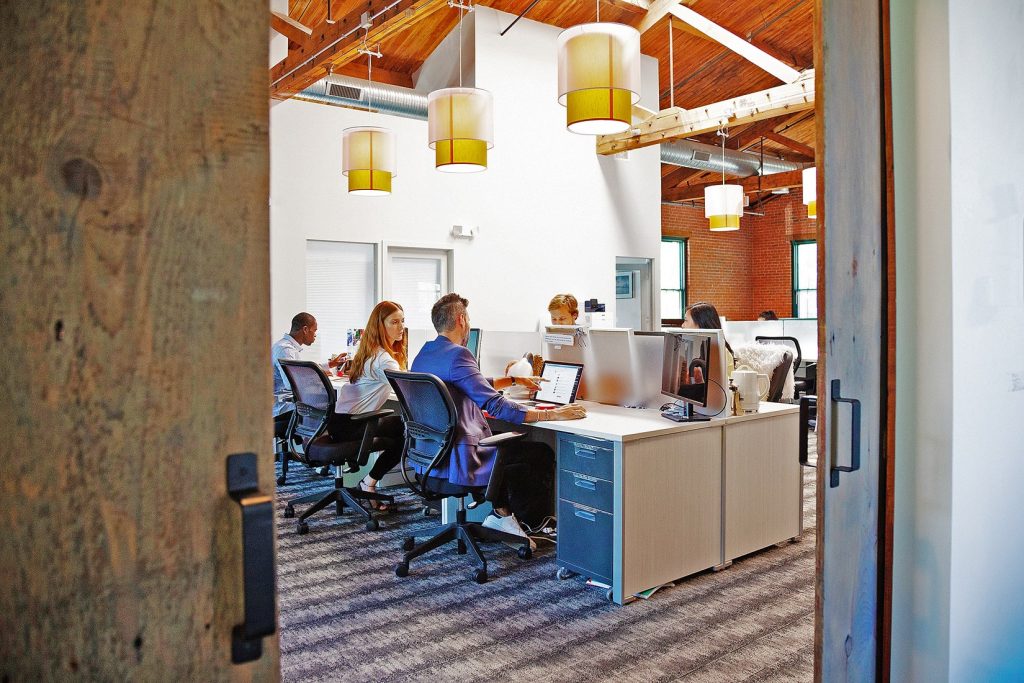 People sitting in the office where the company has sustainable printers for businesses